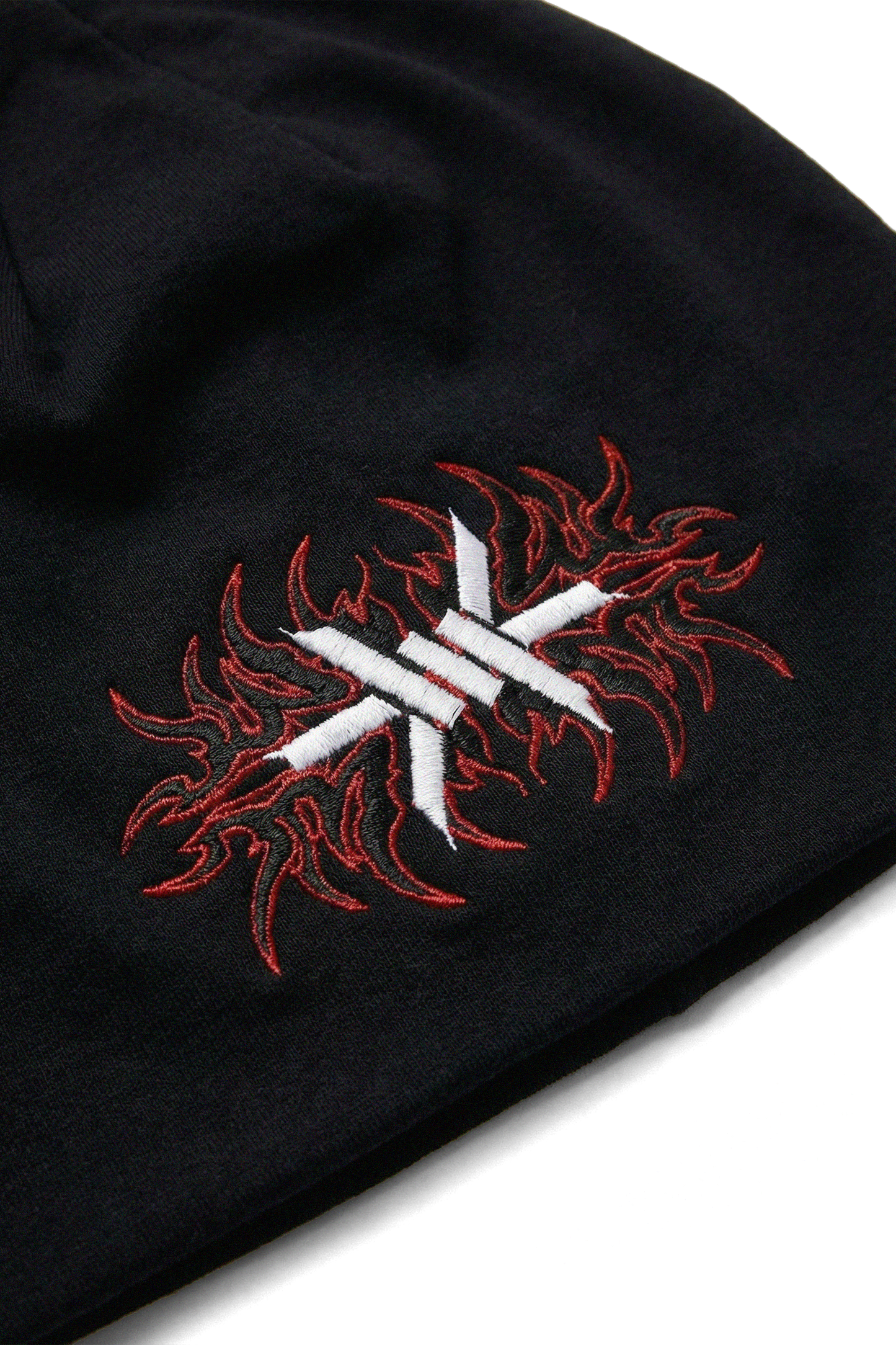 Black skull cap beanie with red and white embroidered design on a white background