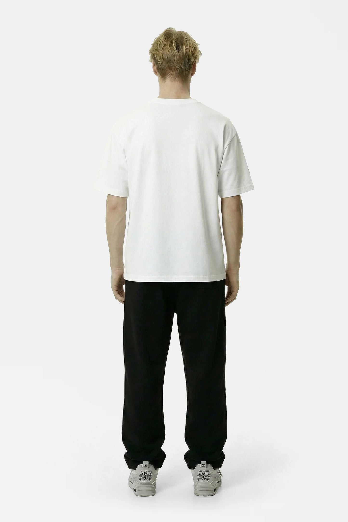 Person wearing a white t-shirt and black pants on a white background