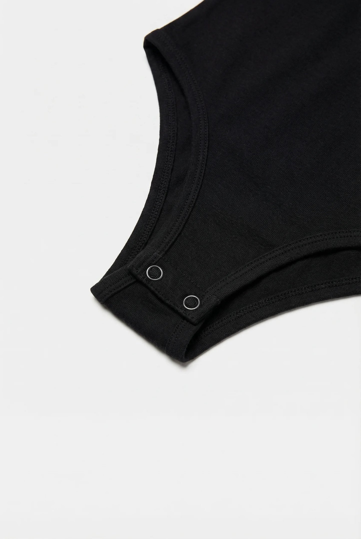 Close up of a black bodysuit on a light gray background