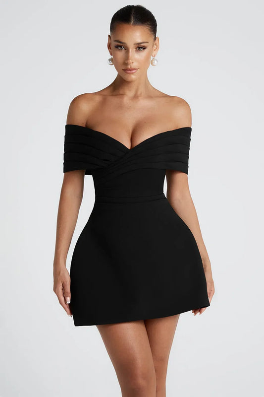 Ella mini dress - Woman wearing a black off-shoulder dress against a white background front model shot