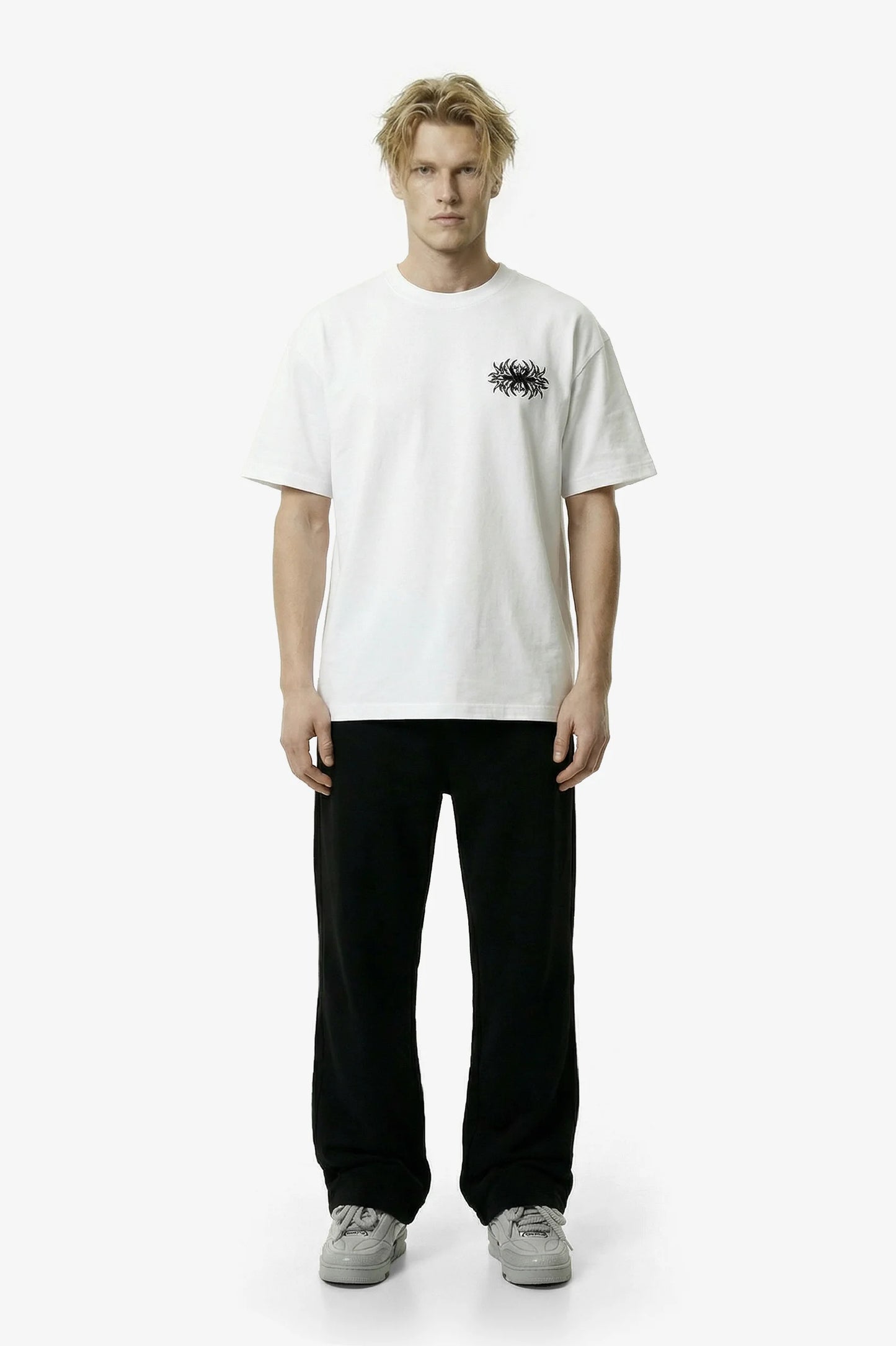 Person wearing a white t-shirt with a small black graphic on a white background